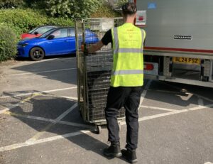 GXO staff in high vis top pushing a trolley